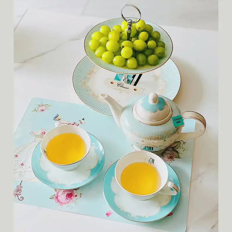 A delicate bone china tea set porcelain teapot in light blue and white floral design with gold trimmed handles and lid
