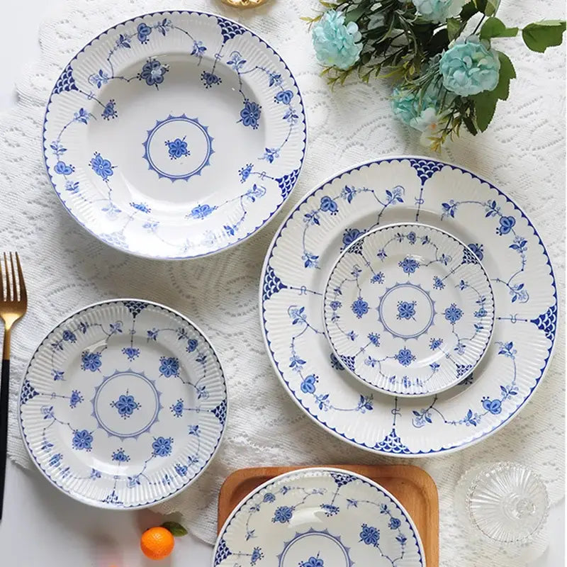 Set of four white porcelain dinner plates with blue floral and geometric patterns from decorbites ceramic dinnerware