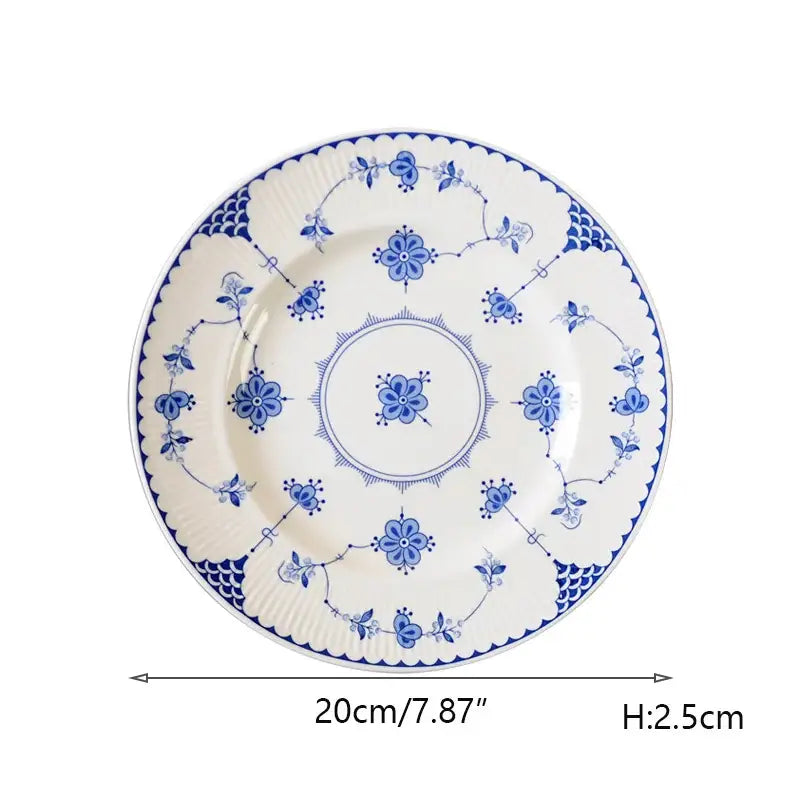 A white ceramic dinner plate with intricate blue floral and vine patterns from decorbites ceramic dinnerware