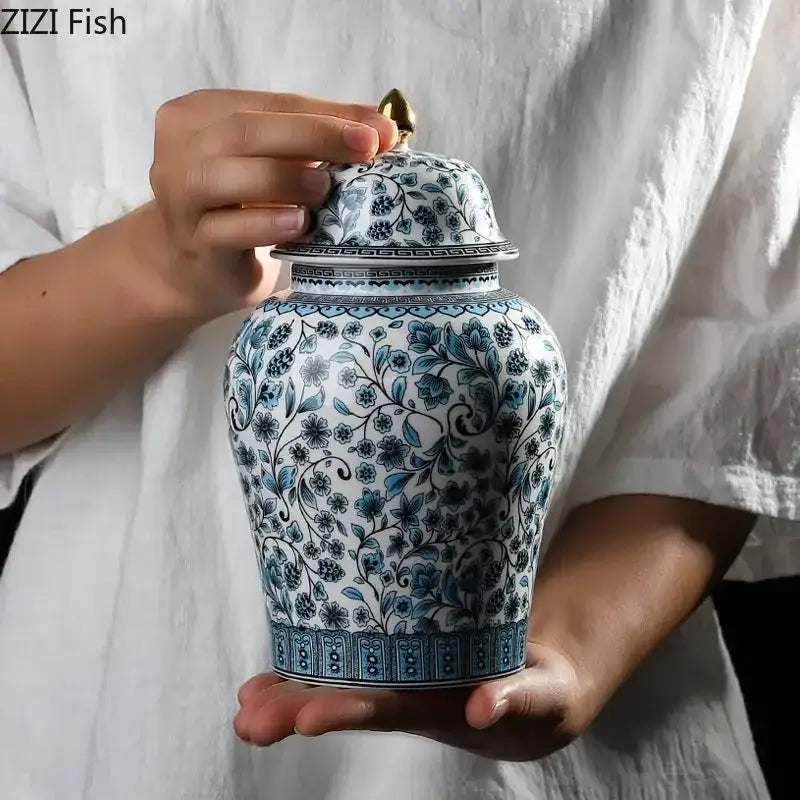 A blue white ceramic ginger jar with intricate floral patterns and gold lid for living room decor by decorbites