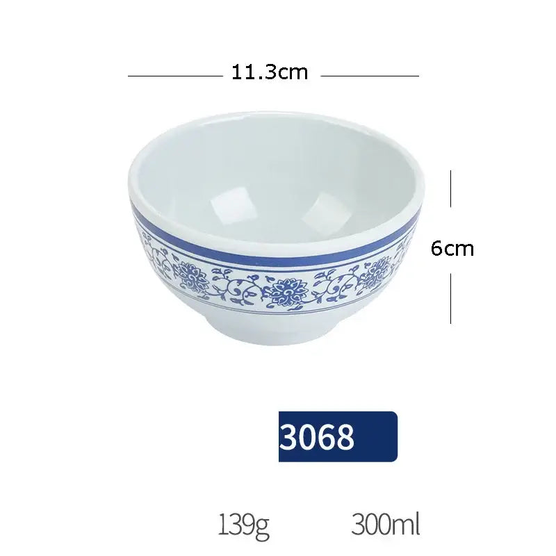 White imitation porcelain dinner set bowl with blue floral and vine pattern and solid blue band around rim