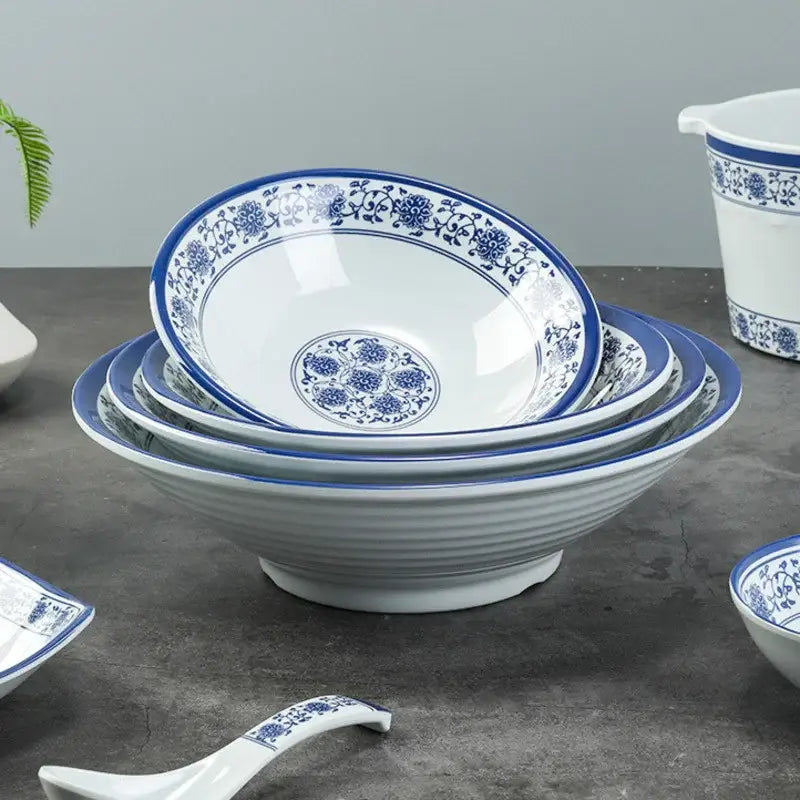Stacked white imitation porcelain dinner set bowls with intricate blue floral patterns and glossy finish for dining room