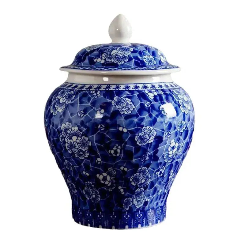 A classic blue white porcelain ginger jar with intricate floral patterns on a crackled white porcelain tea canister
