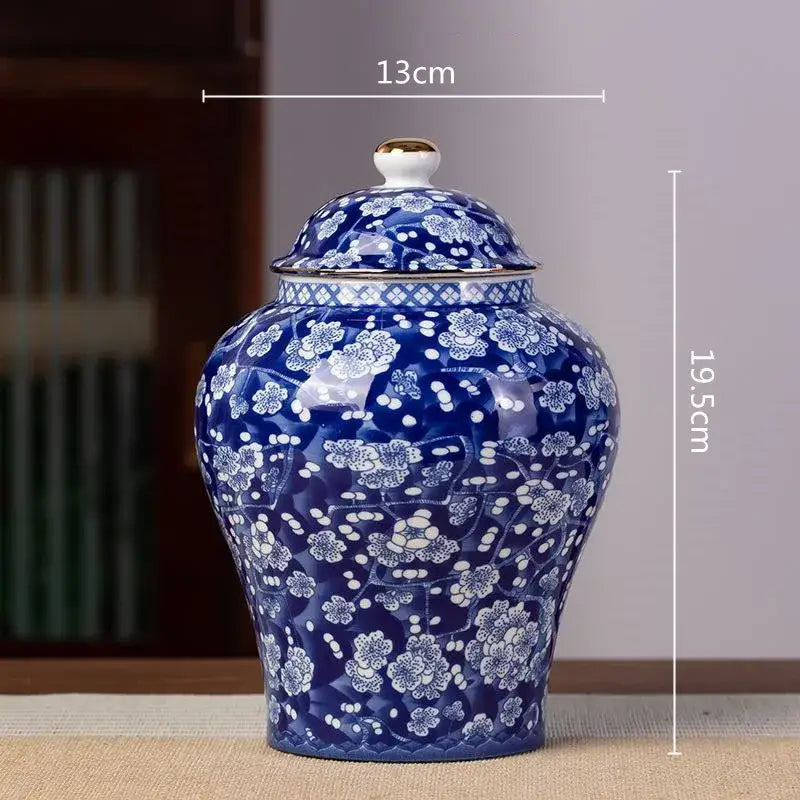 A glossy blue and white porcelain tea pot storage container with intricate floral patterns and gold trim lid