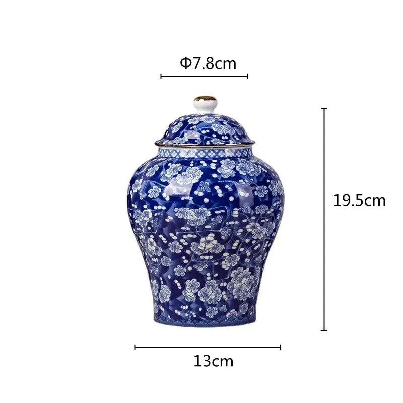 A glossy cobalt blue porcelain tea pot with white floral patterns and gold trim for kitchen storage container use