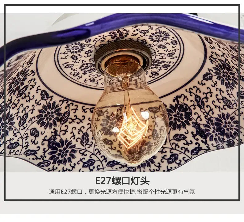 A vintage-style wall lamp with a warm glowing edison bulb housed in a blue white porcelain floral ceramic shade decorbites blue white