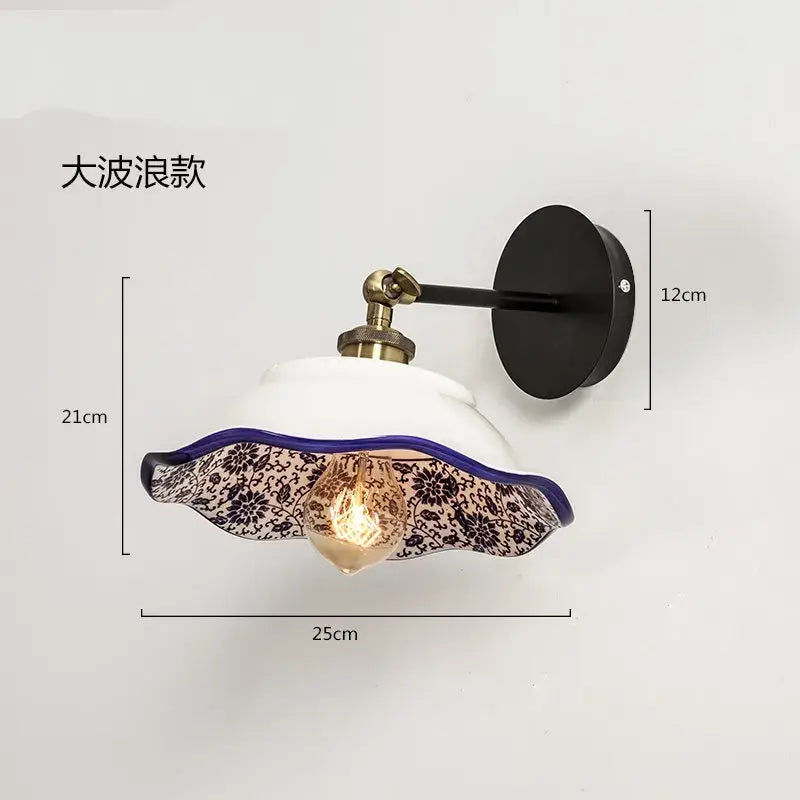 A white ceramic wall lamp with a scalloped black floral glass shade and purple rim decorbites blue white porcelain