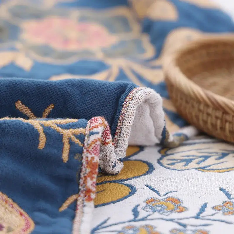 Blue double cotton bohemian throw blanket with intricate gold and pink floral embroidery and decorative woven border