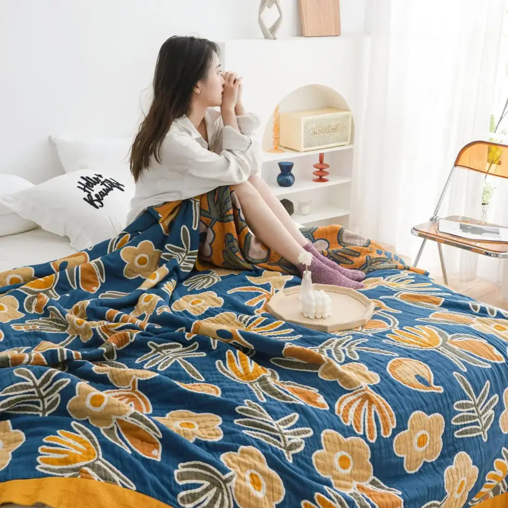 Blue double gauze cotton summer blanket with vibrant yellow and orange floral pattern for bedroom decor