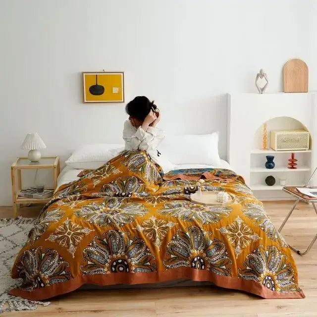 Vibrant mustard-yellow quilted double gauze cotton summer blanket with intricate floral and geometric patterns in earthy tones