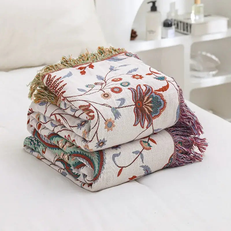 A cream-colored decorbites jacquard cotton gauze sofa cover with embroidered floral patterns and fringed edges
