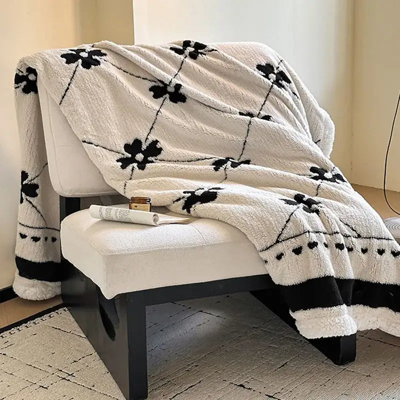 Cream-colored jacquard lamb wool blanket with black floral and heart patterns ideal as a living room throw