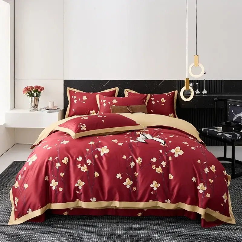 Red satin duvet cover with gold floral embroidery and matching pillowcases in egyptian cotton bedding set