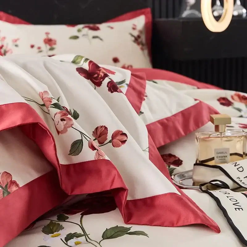White satin egyptian cotton bedding set with embroidered red and pink roses and crimson satin trim on cream background
