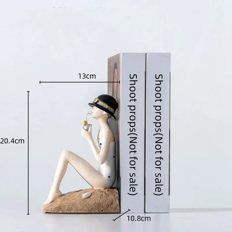 Beige resin figure sculpture of a woman in a black hat with gold trim holding a small object for living room decor
