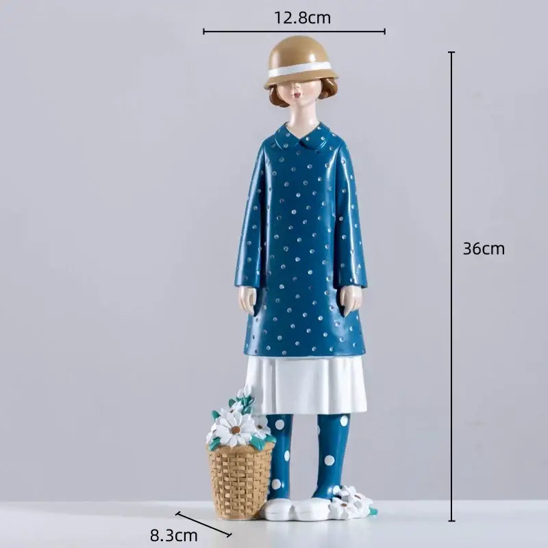 A charming resin figure sculpture of a woman in a blue polka-dot coat and tan hat with a woven basket of flowers