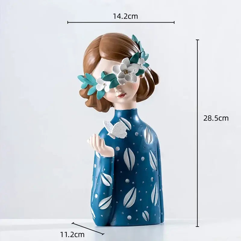 Blue ceramic resin figure sculpture of a girl with brown hair wearing white flower eye cover and leaf pattern dress for decor