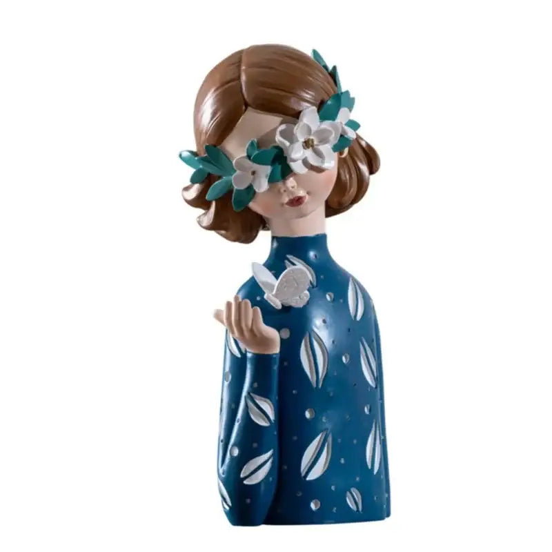 A blue resin figure sculpture of a girl with brown hair wearing a floral crown and leaf-patterned dress for living room decor