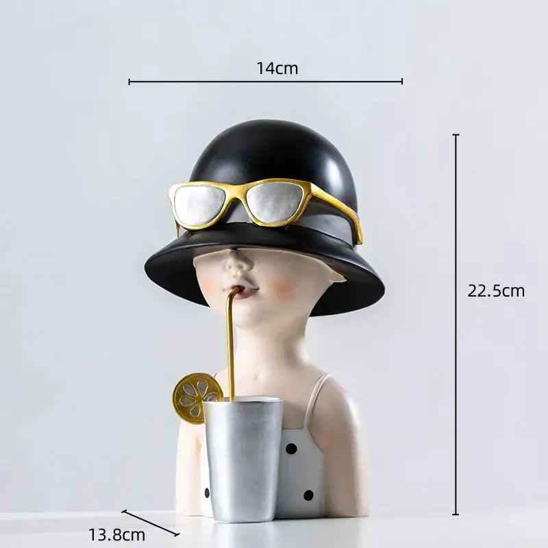 A stylish black hat resin figure sculpture with gold-rimmed sunglasses and silver cup with lemon slice garnish living room decor