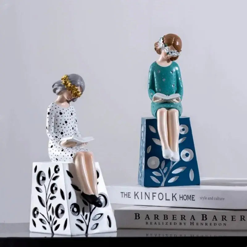 Two ceramic resin figure sculptures of women in vintage polka-dot dresses with floral crown accents for living room decor