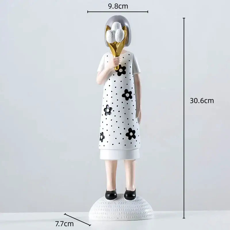 White resin figure sculpture of a woman with gray hair in black floral dress holding golden bouquet for living room decor