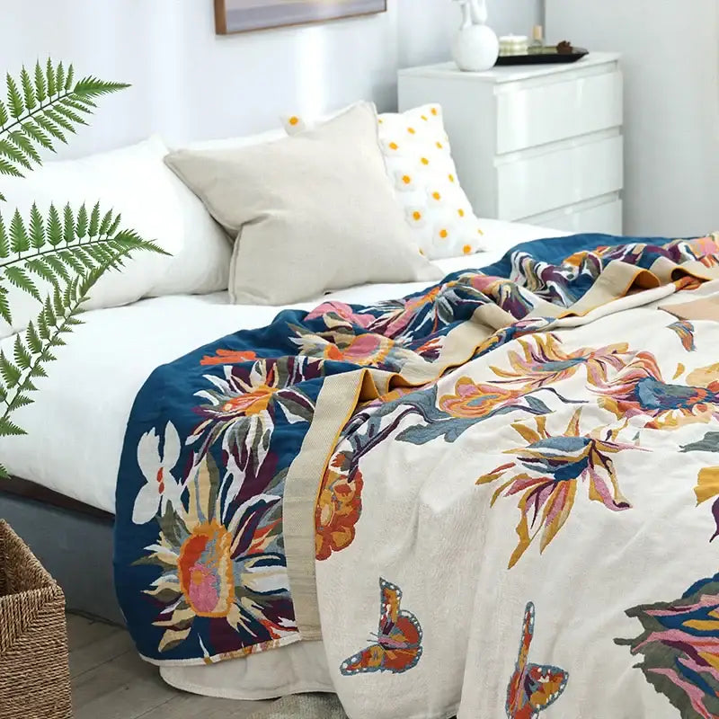 A vibrant floral embroidered cream and navy blue cozy gauze cotton throw with colorful butterfly accents for decorbites cozy gauze decor