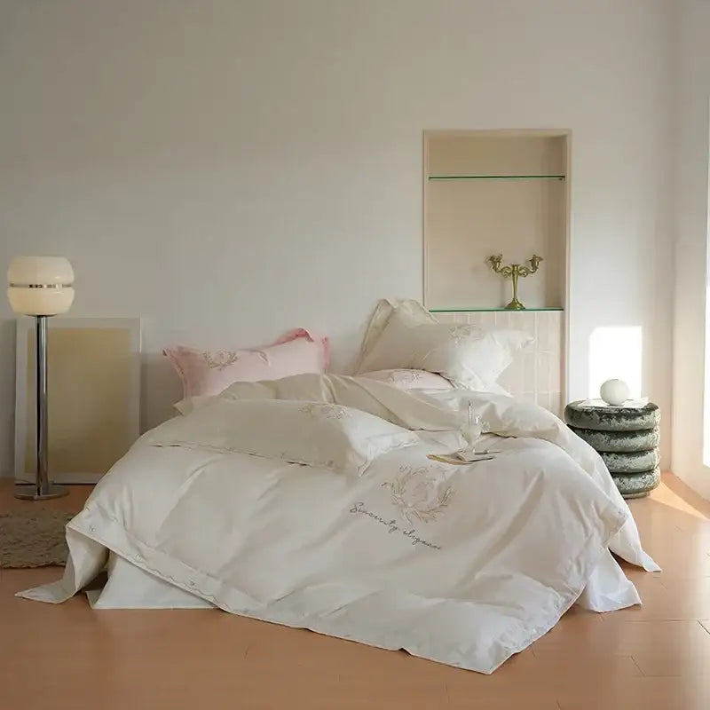 Cream-colored satin duvet cover set with delicate gold floral embroidery and soft luxurious texture for bedroom decor