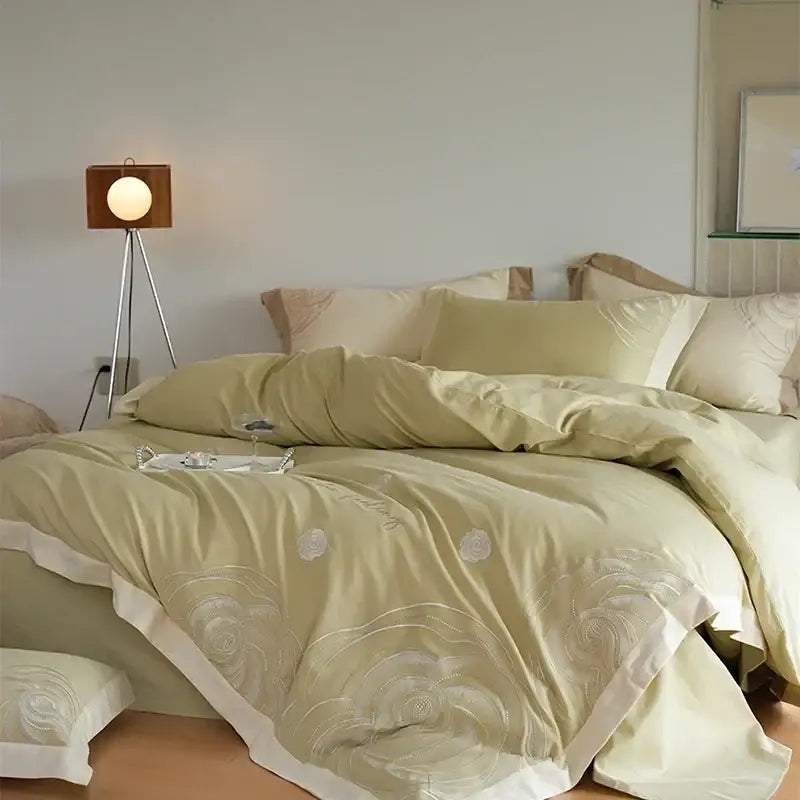 Soft sage green satin duvet cover set with delicate white floral embroidery and cream ruffled edge for bedroom decor