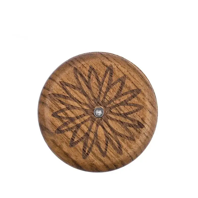 A round wooden button with dark brown floral pattern and silver center for decorbites french bread lame dough scorer set