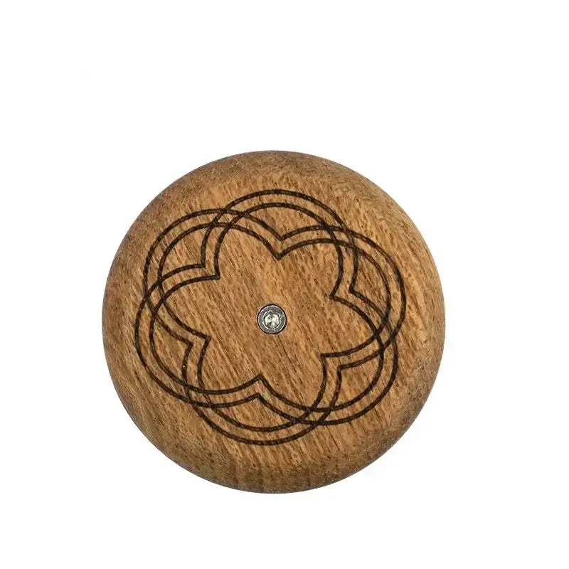 A round light brown wooden knob with dark engraved quatrefoil design for decorbites french bread lame dough scorer set