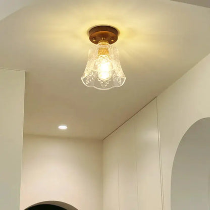 A warm-toned glass led ceiling lamp with brass base and floral etched shade for living room use