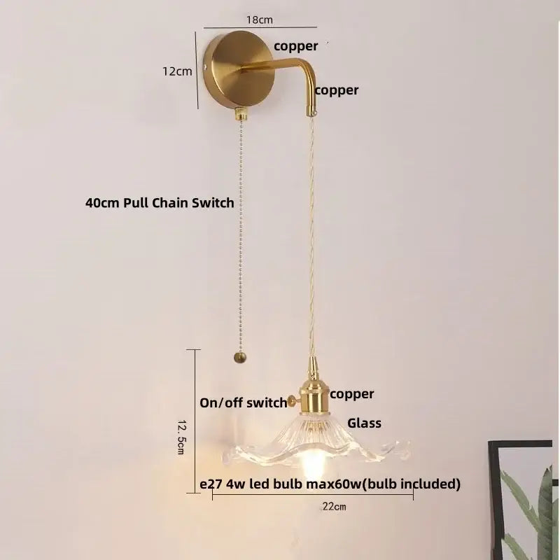 A brass-finished floral glass copper led wall sconce with curved arm and clear shade includes 4w led bulb for bathroom use
