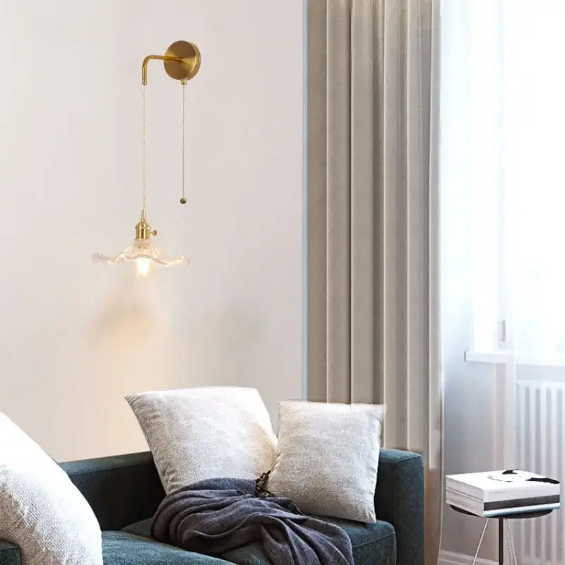 Gold-toned floral glass copper led wall sconce with delicate curved arm and ornate glass shade for bathroom light
