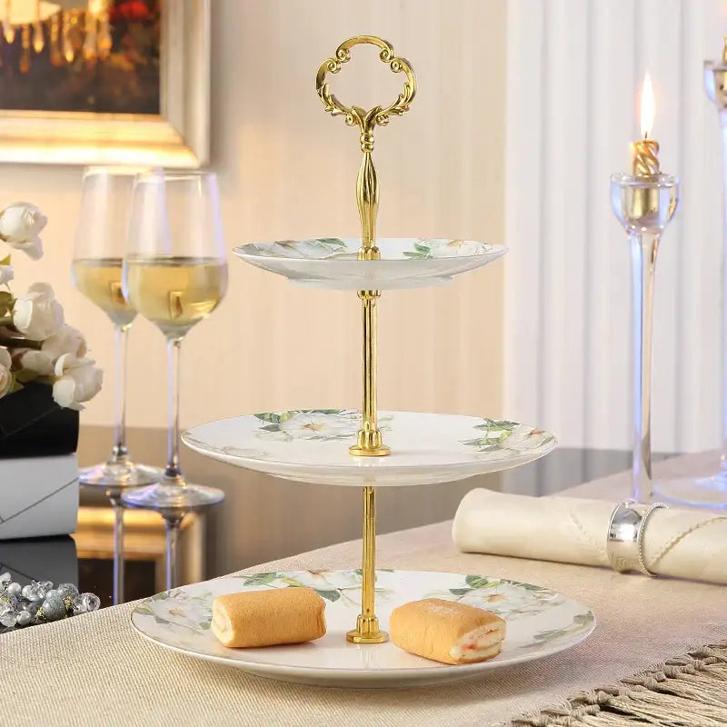 Three-tiered serving stand with gold-toned metal frame and white floral bone china fruit plates set for dining room use