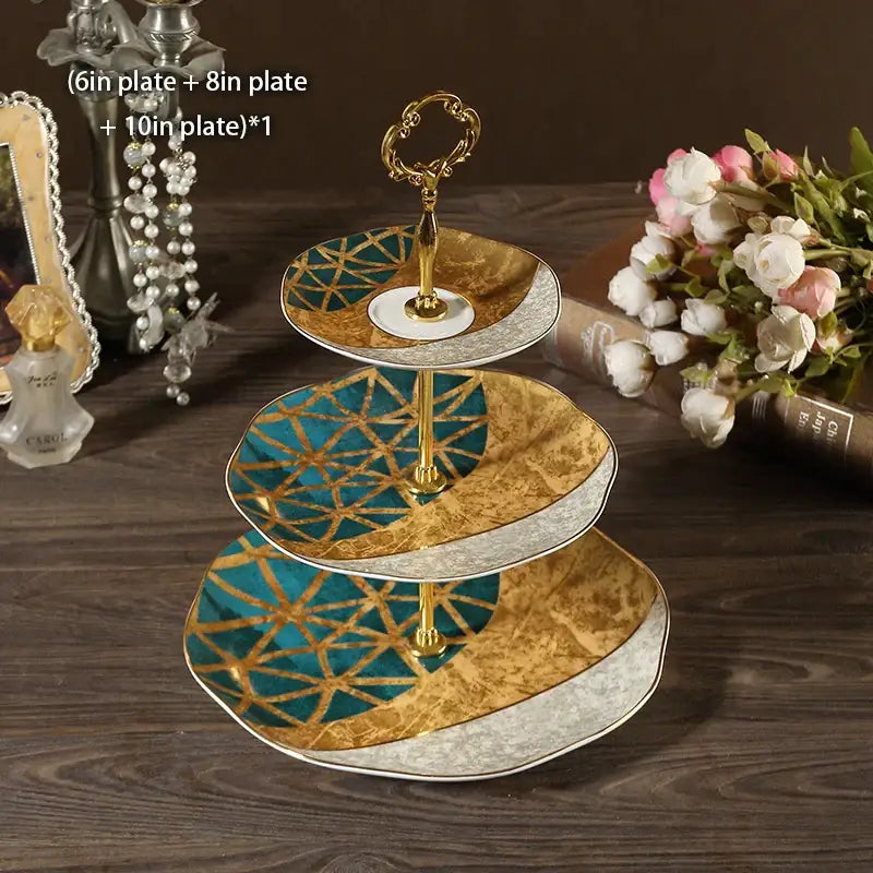 Three-tiered bone china fruit plates set with ornate gold and teal geometric floral design and silver trim tiered stand