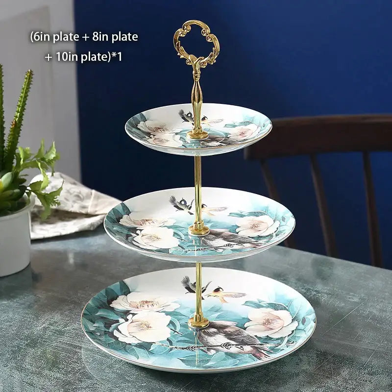 Three-tiered bone china fruit plates set with floral and bird motifs and gold-toned ornate handle for dining room use