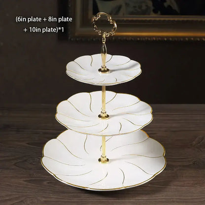 White ceramic three-tiered bone china fruit plates set with gold leaf detailing and decorative golden handle for dining room