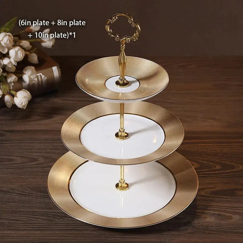Gold-trimmed three-tiered bone china fruit plates set with white ceramic plates and ornate gold handle for dining room use