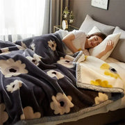 A cozy flocked raschel blanket in dark gray with soft plush texture and white yellow floral patterns for bedroom decor