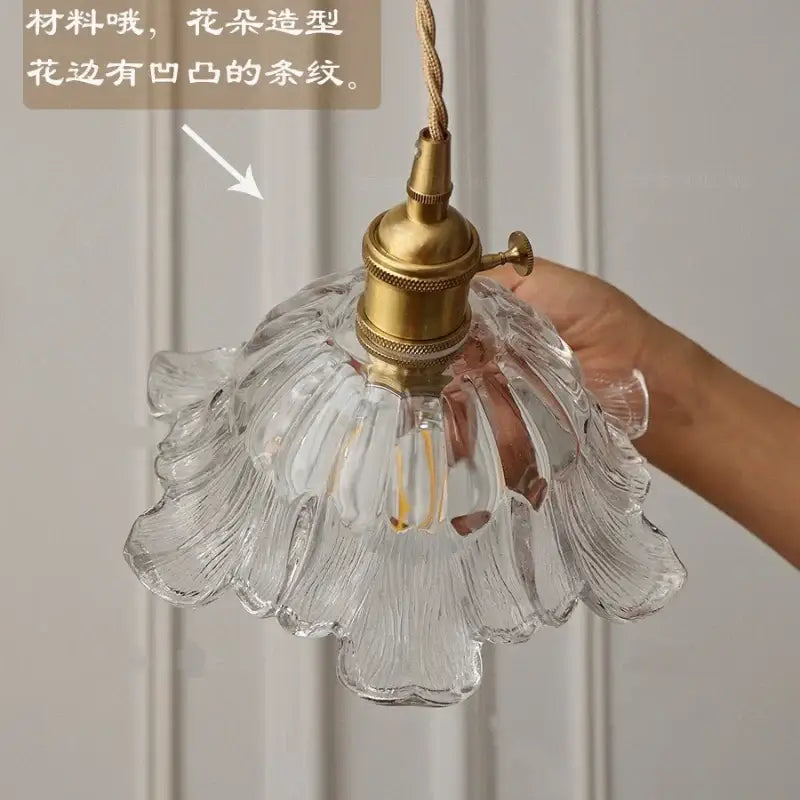 Clear glass pendant light with flower-shaped ribbed design and brass hardware for dining room use