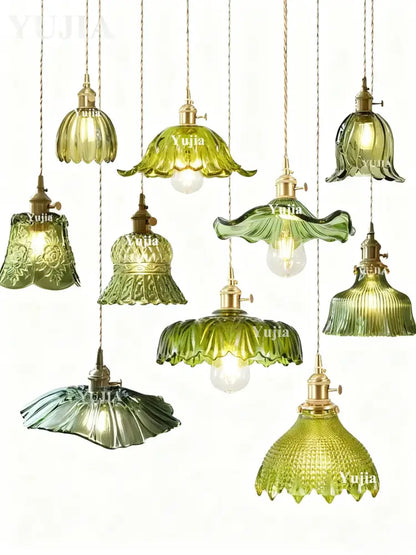 A collection of elegant pendant lights with green glass shades and brass fixtures featuring floral and ruffled designs