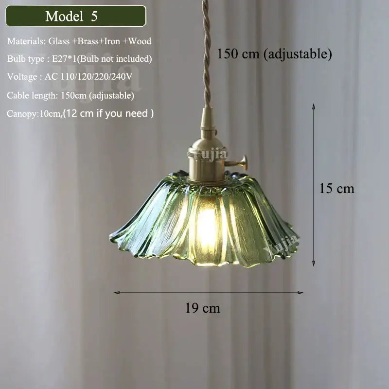 A delicate green glass pendant light with a fluted petal-like green glass shade and brass hardware for kitchen use