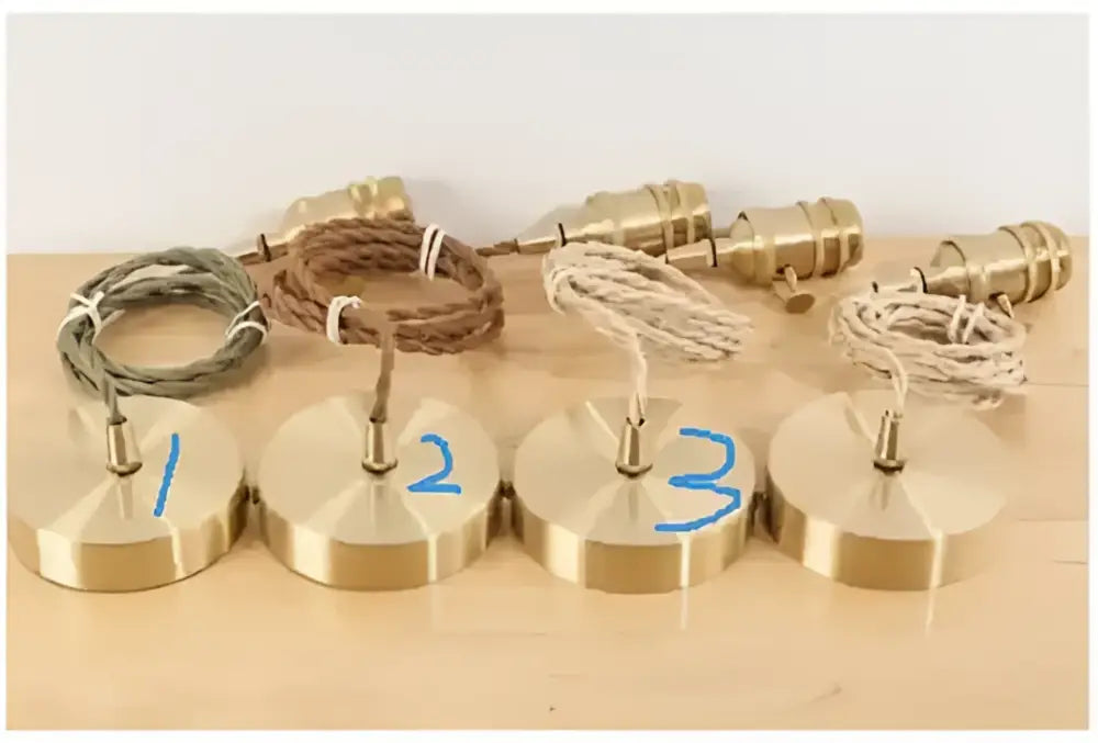 Four brass pendant lights with floral green glass pendants and braided cords for dining room lighting