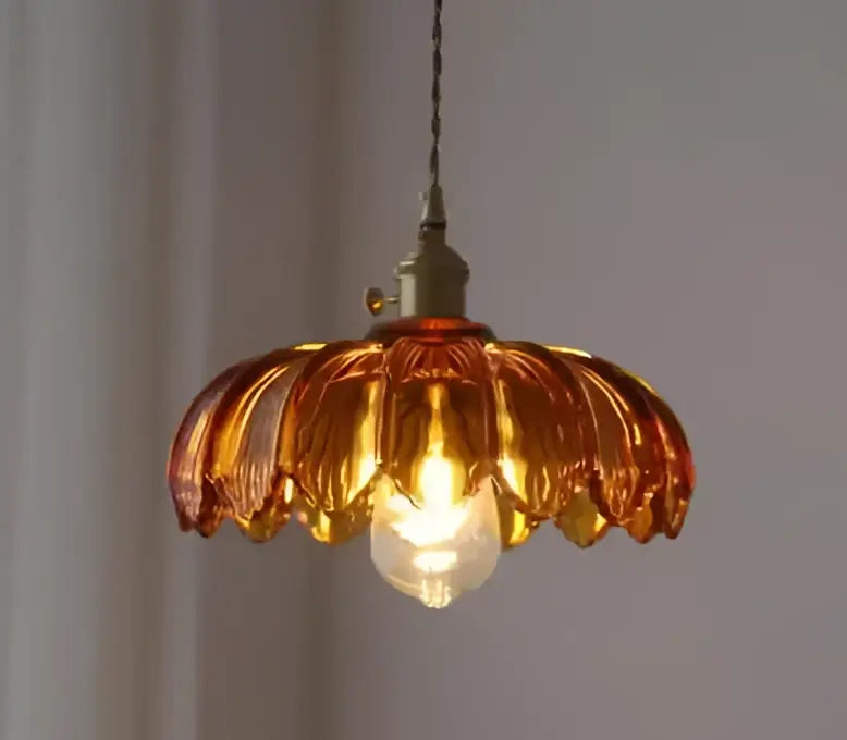 Amber-colored glass pendant light with brass finish and exposed bulb for dining room glass pendant lights