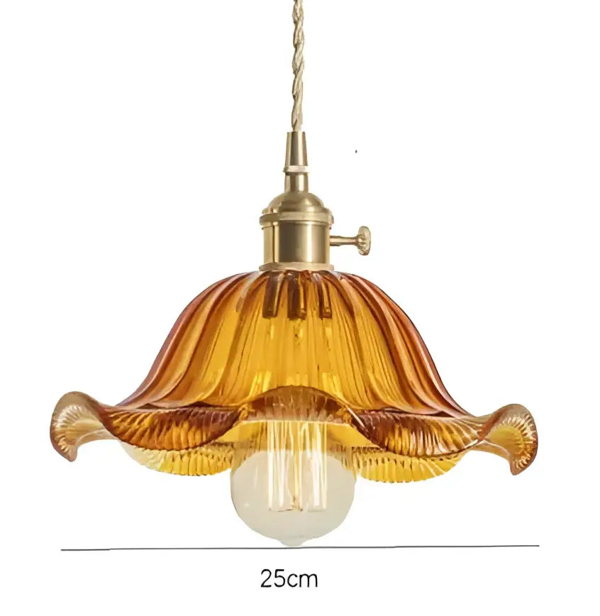 A warm amber glass pendant light with fluted petal design and golden brass finish for dining room pendant lights