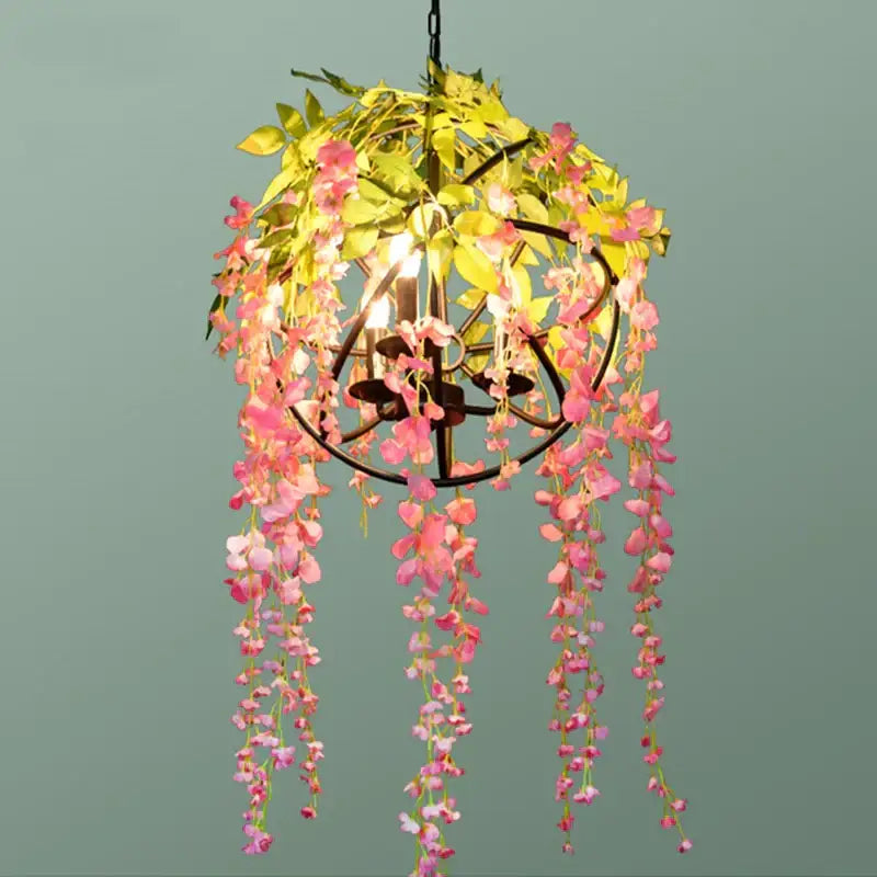 A delicate pink and yellow floral green plant lighting chandelier with cascading artificial blossoms on dark metal frame for dining room decorbites green plant