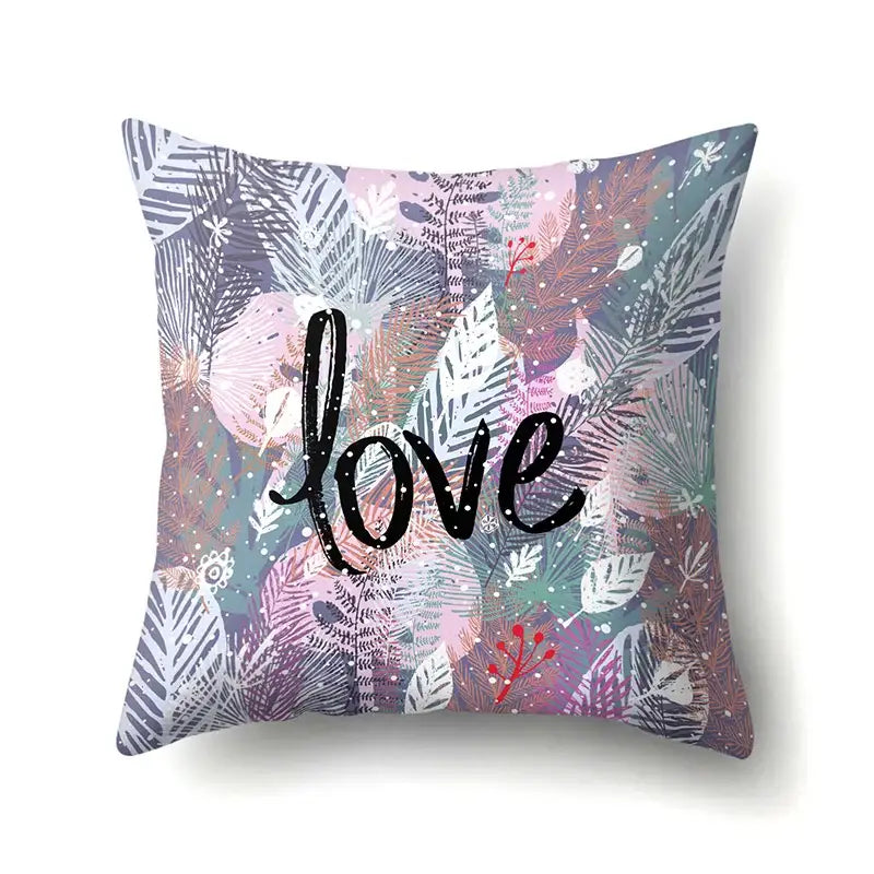 A square pillow cover with decorbites green tropical leaves and love in bold black script for seasonal decor