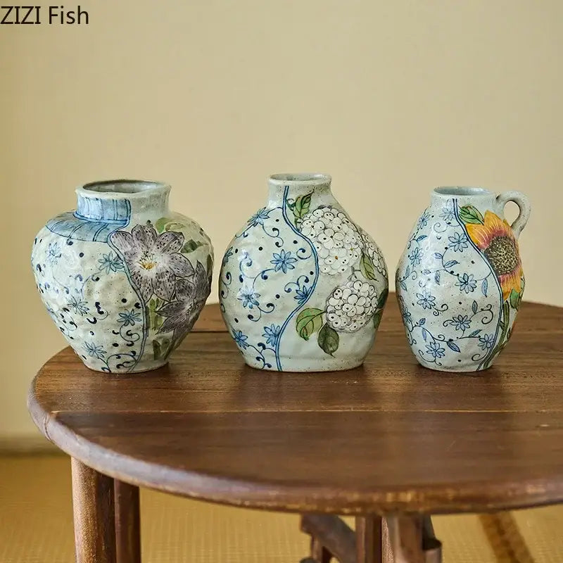 Three hand-painted decorbites ceramic vases with floral designs and artificial flowers for living room decor