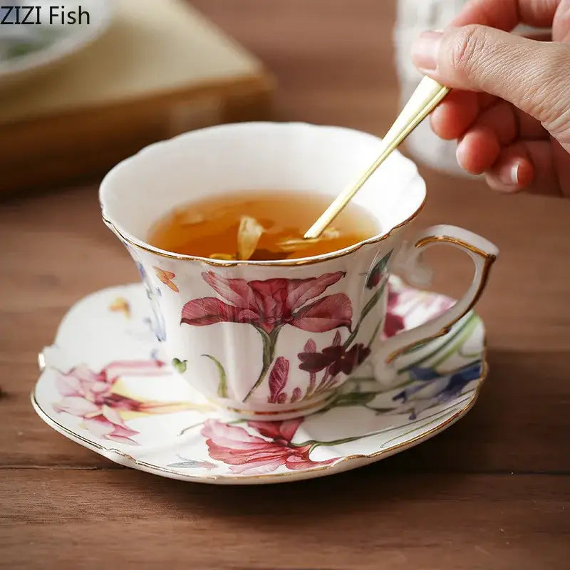 A delicate white porcelain teacup and saucer with vibrant pink and purple decorbites iris pattern and gold trim mug set