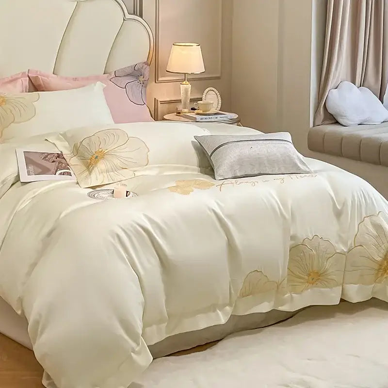 Cream-colored satin duvet cover and pillowcases with delicate gold floral embroidery in embroidered egyptian cotton bedding set